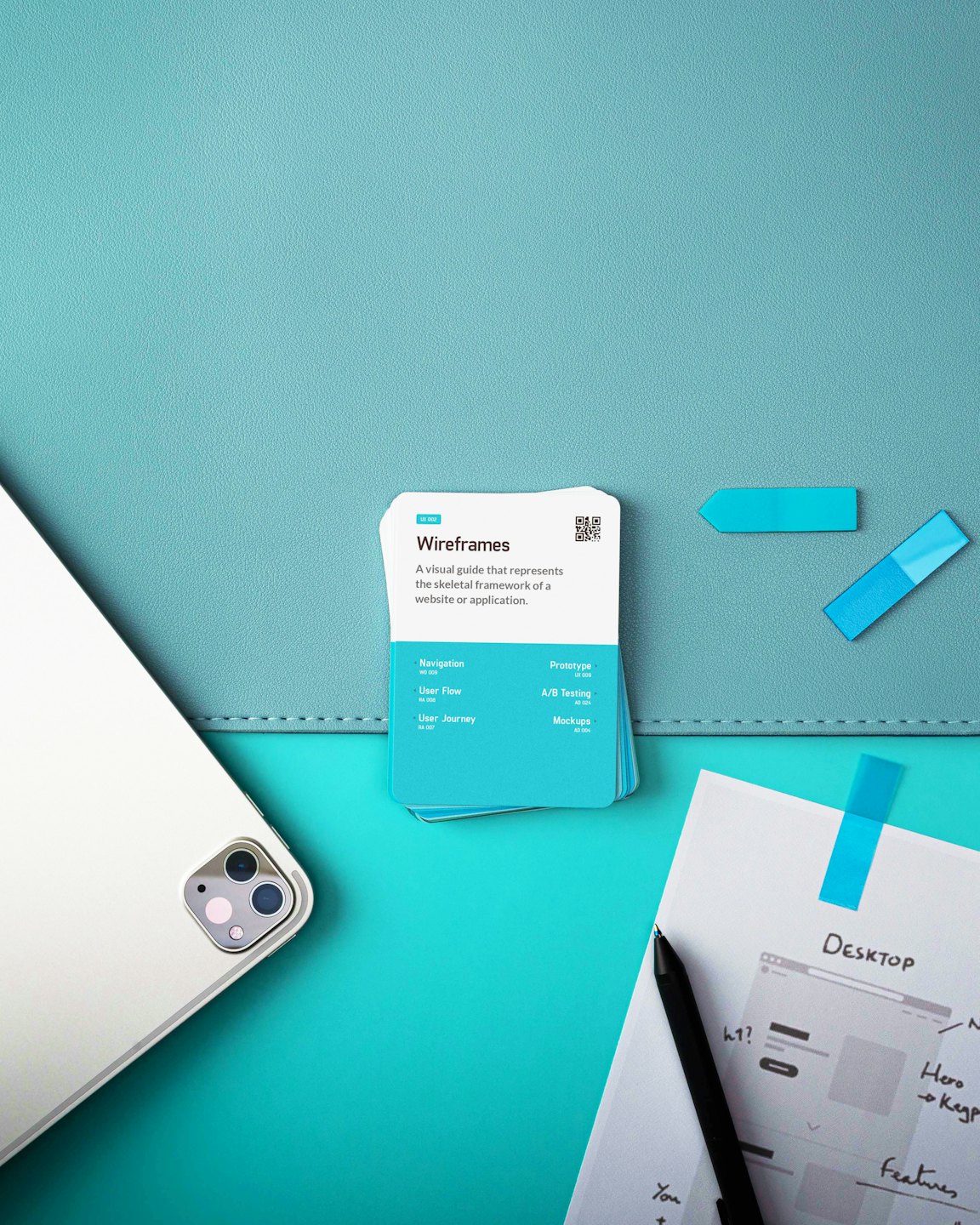 Tablet and cards for UX/UI design laid out on a teal background.